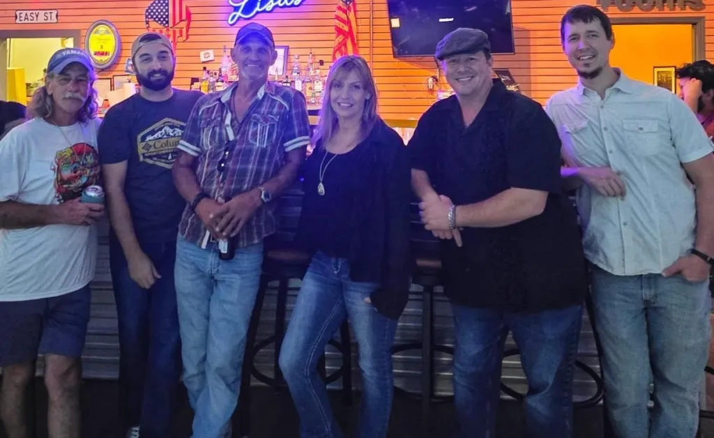 River Rats band performing live in North Florida with guitars, drums, and upbeat crowd energy during a high-energy show.